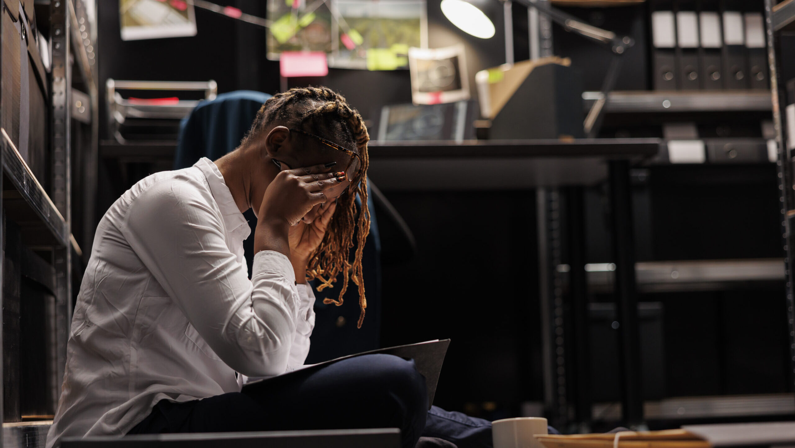 Tired police detective having headache while working late